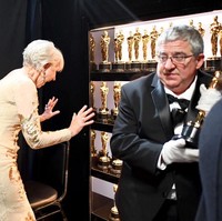 Kelakuan konyol Helen Mirren di depan lemari berisi Piala Oscar. I want all that trophy!! Foto: Getty Images