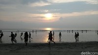 Selain duduk dipinggir pantai, tak sedikit wisatawan asing yang berbaur dengan warga lokal untuk bermain bola di pantai. Ada pula yang berjalan-jalan dan bermain dengan anjing peliharaan (Bonauli/detikTravel)