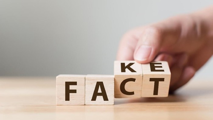 Fact or Fake concept, Hand flip wood cube change the word, April fools day