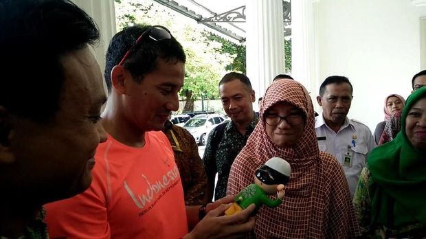 Sandiaga memegang mainan anak yang dijual warga.