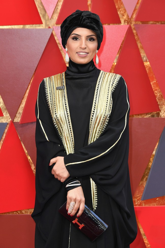 Fatma Al Remaihi mengenakan bisht berwarna hitam dengan aksen keemasan. Ia memadukan bisht tersebut dengan turban berbahan beludru dengan warna hitam pekat.Foto: Getty Images