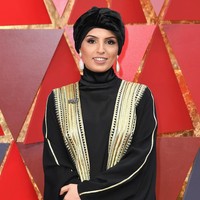 Fatma Al Remaihi mengenakan bisht berwarna hitam dengan aksen keemasan. Ia memadukan bisht tersebut dengan turban berbahan beludru dengan warna hitam pekat.Foto: Getty Images