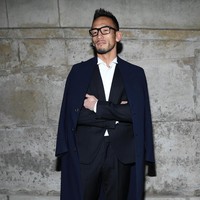 Fashion show ini juga tak dilewatkan oleh mantan pesepak bola Jepang Hidetoshi Nakata yang gagah dalam balutan setelan dan sneakers serta mantel. Foto: Getty Images