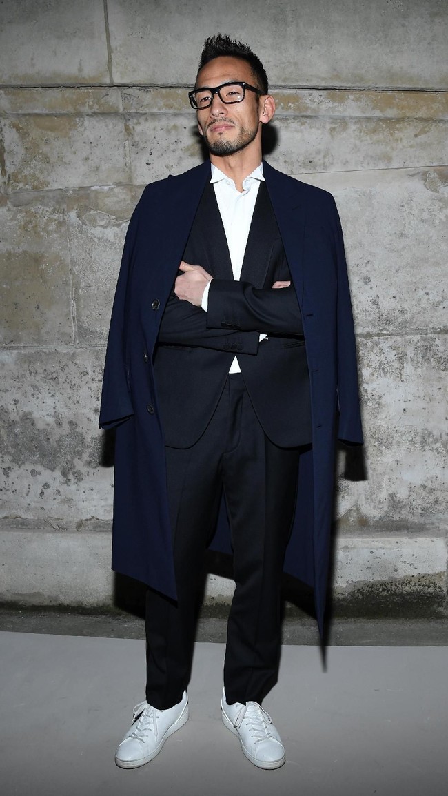 Fashion show ini juga tak dilewatkan oleh mantan pesepak bola Jepang Hidetoshi Nakata yang gagah dalam balutan setelan dan sneakers serta mantel. Foto: Getty Images