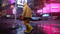 Seorang pria tampak membersihkan salju di depan Times Square, New York. 