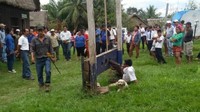 Delgado dipasung karena dianggap ingkar pada janjinya sendiri. Delgado juga disebut tidak pernah menerima warga di kantornya. Saat Delgado datang, warga menolak untuk menerimanya jika Delgado tidak dipasung terlebih dahulu.  (Foto: Río Beni TV via BBC Mundo)