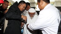 Abu Bakar Baasyir yang mengenakan gamis dan peci putih keluar dari mobil.