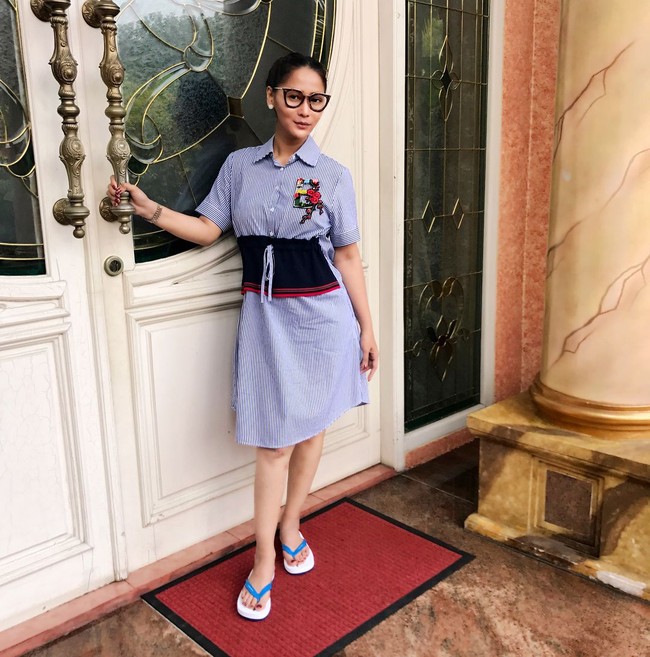 Gaya Inul Daratista berpose di depan pintu rumahnya dengan stripe dress dan kacamata. Pedangdut yang dikenal lewat goyang ngebor ini pun melengkapi penampilannya dengan sandal jepit dari rumah mode Dolce & Gabbana, dengan harga yang ditaksir senilai Rp 1,5 juta. Foto: Instagram