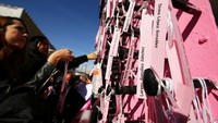 Nama setiap wanita yang menjadi korban pembunuhan di Ciudad Juarez, dipasangkan pada memorial berbentuk salib dan berwarna mayoritas merah muda ini. Memorial ini diletakkan di perlintasan perbatasan internasional Paso del Norte, Ciudad Juarez. Foto: REUTERS/Jose Luis Gonzalez