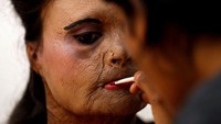  Sebelum tampil di peragaan busana, para korban serangan air keras secara bergiliran dirias wajahnya. Foto: REUTERS/Danish Siddiqui
