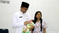 Anies Baswedan menggendong bayi saat mengunjungi Puskesmas Kecamatan Setiabudi, Jakarta Selatan, Jumat (9/3).