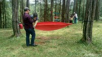 Tak hanya anak-anak muda, traveler yang sudah berkeluarga juga asyik tamasya ke sini. Sang ayah terlihat membantu anaknya duduk di atas hammock. (Dadang/detikTravel)