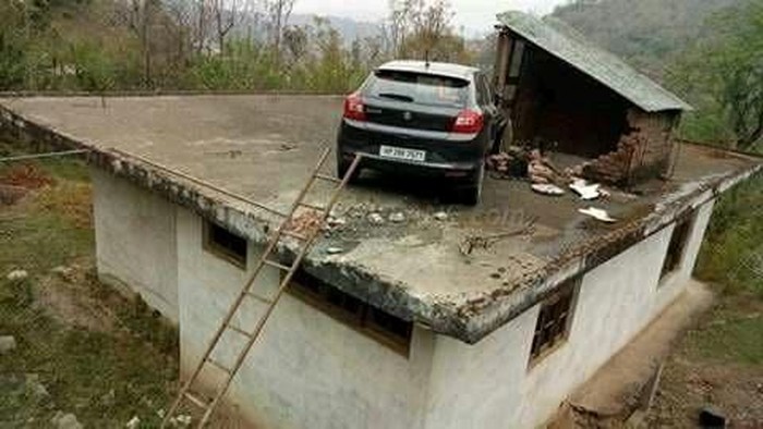 Kecelakaan, Buat Mobil Ini Tersangkut di Atap Rumah
