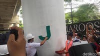Anies mengecat huruf J di tiang tersebut.