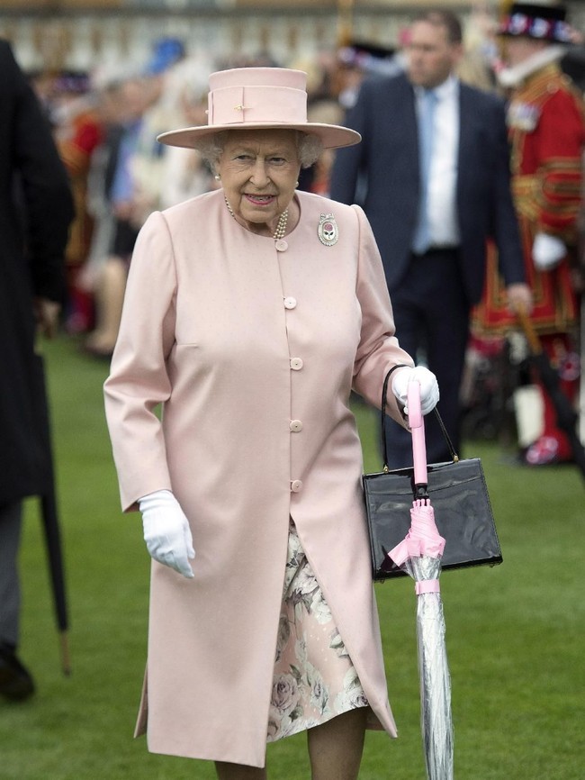 Giliran busana dan payung merah muda yang jadi andalannya saat menyambangi Metroline Tramline Extension di London, 2015 silam.  Foto: dok: Getty Images