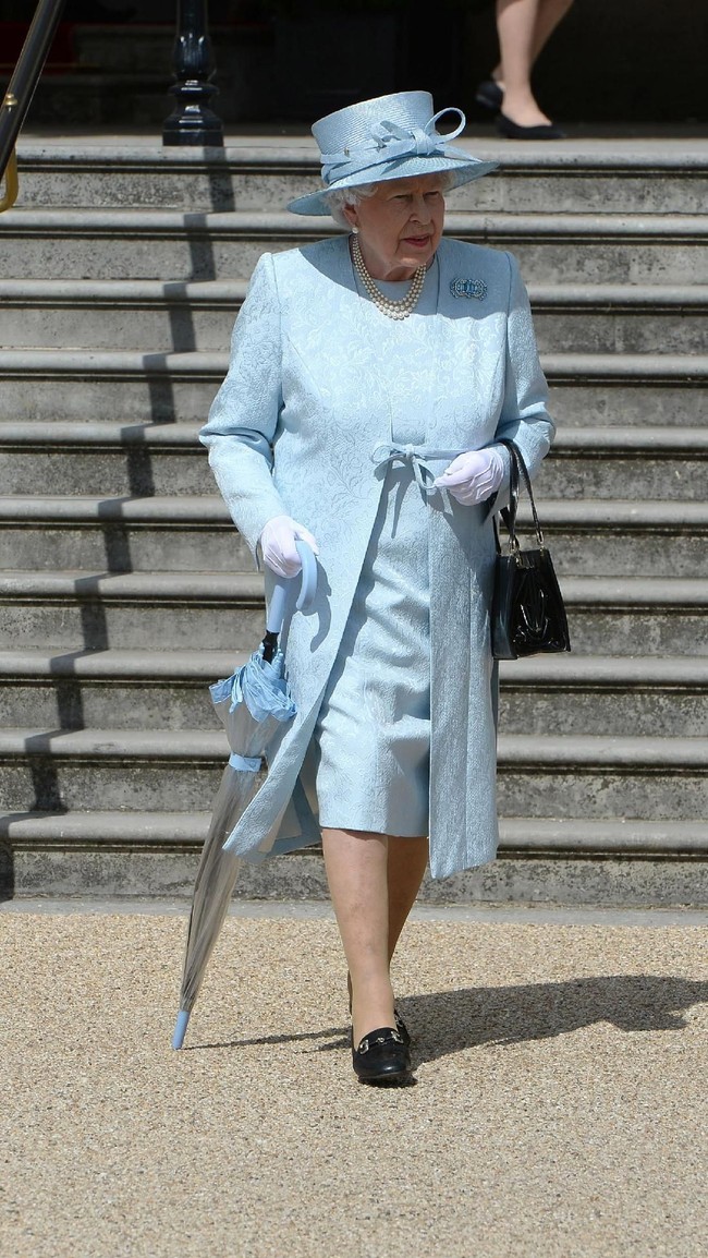 Menghadiri sebuah pesta kebun di Buckingham Palace, London, Inggris, pada 2017 silam, Ratu Elizabeth tampil dengan busana serba biru berikut payung transparan dengan pinggiran berwarna senada.  Foto: dok: Getty Images