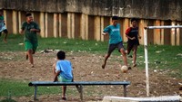 Sepakbola tersebut berlangsung seru meski digelar di pinggir sungai.