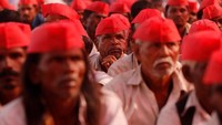 Dalam aksinya, para petani ini memakai peci merah dan melambaikan bendera merah partai komunis. Mereka juga meneriakkan tuntutan mereka seperti kenaikan harga pangan dan susu. Foto: REUTERS/Danish Siddiqui