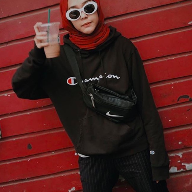 Gayanya memang khas. Ia sering tampil boyish dengan oversized jaket dan kaca mata hitam. Biasanya gaya hijabnya justru sangat simple seperti shawl yang direkatkan di dagu dan ia ikat di belakang leher. Foto: Instagram/strngrrr