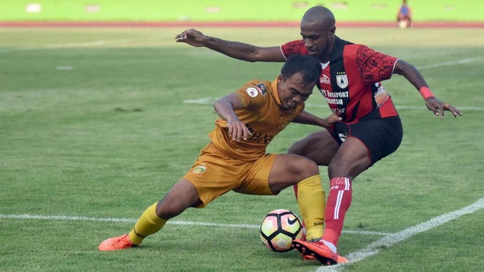 Pesepak bola Bhayangkara FC Fatchurahman (kiri) merebut bola dari pesepak bola Persipura Jayapura Boaz T.E Solossa (kanan) dalam laga persahabatan JakaJaya 2018 di Stadion Gelora Delta Sidoarjo, Jawa Timur, Minggu (11/3). Bhayangkara FC dikalahkan Persipura Jayapura dengan skor 0-1. ANTARA FOTO/M Risyal Hidayat/pd/18