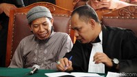 Aman Abdurrahman berdiskusi dengan kuasa hukumnya di sela-sela sidang.