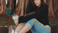 Awkarin minum segelas greentea latte di bawah pohon besar. Lagi ngadem ya? Foto: Instagram @awkarin