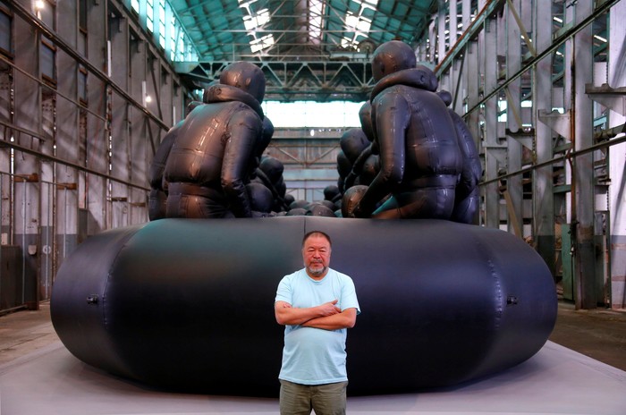Seniman China Ai Weiwei berdiri di depan karya seninya: Law of the Journey Chinese artist Ai Weiwei stands in front of his artwork consisting of a 60-metre rubber raft installation titled 'Law of the Journey' which includes around 300 figures representing refugees, during a media call for the Biennale of Sydney located in the industrial precinct of Cockatoo Island in Australia, March 12, 2018. REUTERS/David Gray NO RESALES NO ARCHIVE