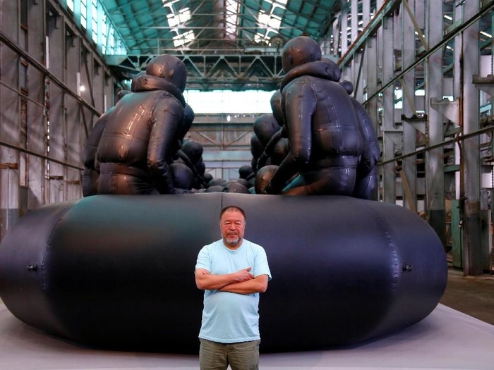 Chinese artist Ai Weiwei stands in front of his artwork consisting of a 60-metre rubber raft installation titled Law of the Journey which includes around 300 figures representing refugees, during a media call for the Biennale of Sydney located in the industrial precinct of Cockatoo Island in Australia, March 12, 2018.   REUTERS/David Gray   NO RESALES NO ARCHIVE