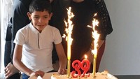 Bersama sang ibu dan juga anaknya, pria ganteng ini merayakan ulang tahunnya dengan kue sederhana berwarna putih dan kedua lilin yang terlihat seperti air mancur api. Foto: Instagram Cristiano