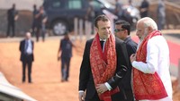 Macron dan Modi mengenakan kain sari yang dililitkan di leher mereka. Keduanya juga tampak berbincang akrab. (Foto: REUTERS/Ludovic Marin)