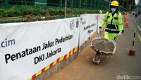 Para pekerja memperbaiki trotoar di Jalan Gatot Subroto, Jakarta, Rabu (13/3/2018).