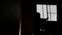 Seorang tahanan tengah termenung di dekat jendela penjara.