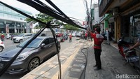 Petugas membersihkan kabel yang semrawut di Jalan Margonda.