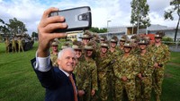Turnbull mengajak para tentara untuk selfie bersama.