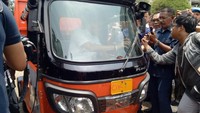 Foto: Sandiaga ternyata tertarik mencoba mengendarai bajaj itu. Dia lalu masuk dan duduk di belakang kemudi bajaj. Orang nomor dua ini awalnya dibantu stafnya untuk mengendarai kendaraan roda tiga itu. Fotografer: Muhammad Fida Ul Haq