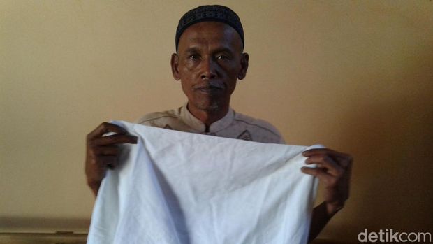 Sabil menunjukkan kain mori pembungkus uang