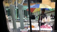 Pedagang menggelar dagangan di atas boks-boks. Mereka juga menbentangkan payung untuk melindungi diri dari sengatan sinar matahari.
