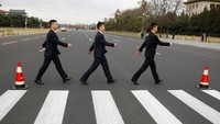 Ini bukan sesi pemotretan seperti anggota The Beatles tapi petugas keamanan yang sedang berjaga di konferensi parpol di Beijing, China. 