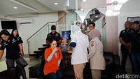 Foto: Jennifer Dunn yang didampingi anggota polisi kemudian menuju ruangan Direktorat Narkoba Polda Metro Jaya. Dia diperiksa oleh tim Dokkes Polda Metro Jaya.Fotografer: Kanavino/detikcom