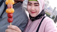 Masih di Korea, pasangan Dendy ini berpose sambil makan camilan khas Korea. Apa ya itu? Foto: Instagram @oviekwie_nyoklat_klasik