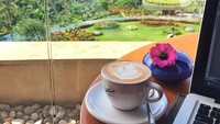 Kali ini pemandangan Dee saat bekerja bukan lagi dapur atau pasar. Hamparan hijau pemandangan alam Ubud sambil ditemani kopi berhias latte art. Nikmat! Foto: Instagram deelestari