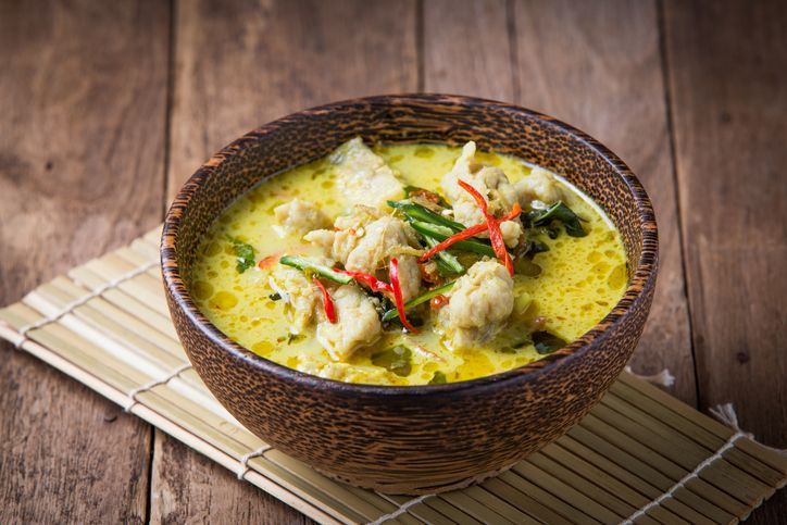 Hot and spicy pork green curry on a wood table