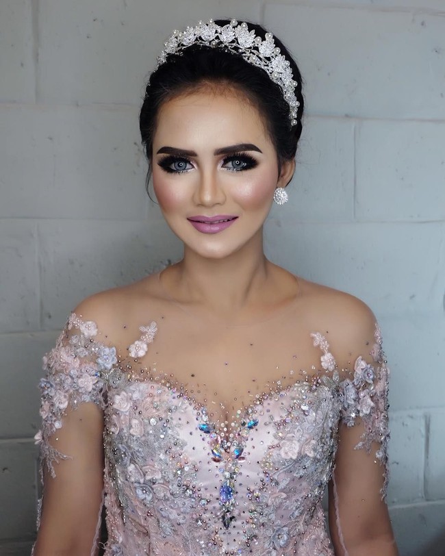 Makeup glamour masih diterapkan makeup artist  Epulpermadi untuk resepsi Ismi Aisyah. Penampilan Bripda Ismi saat pesta pernikahannya ini mendatangkan ragam komentar dari netizen. Sebagian besar menyebut polwan cantik ini jadi mirip penyanyi Krisdayanti. Kalau menurut kamu bagaimana? Foto: Instagram/ismiaisyah20,epulpermadi