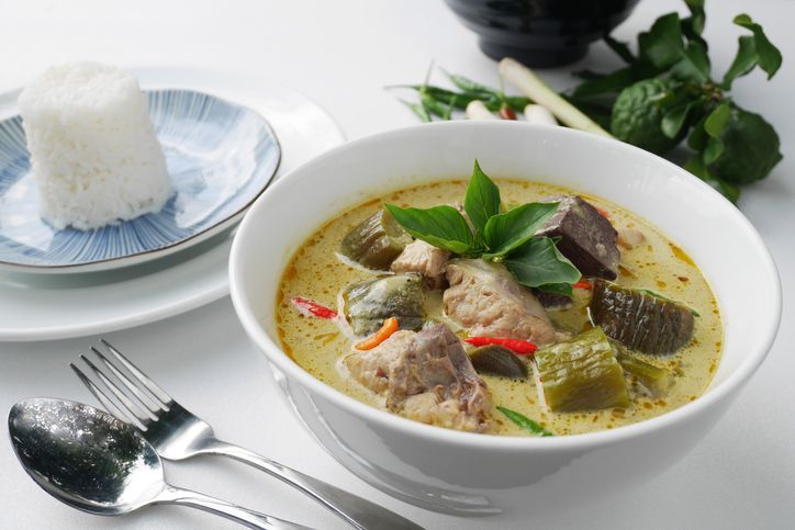 Hot and spicy pork green curry on a wood table