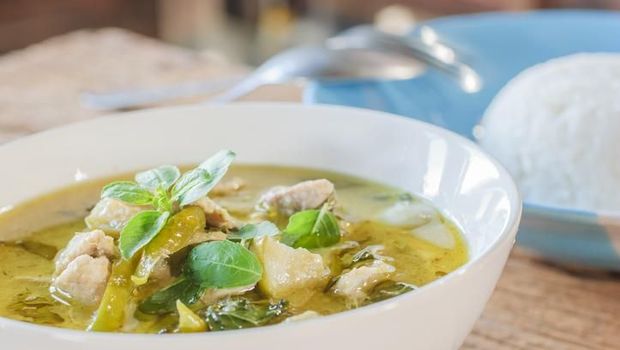 Hot and spicy pork green curry on a wood table