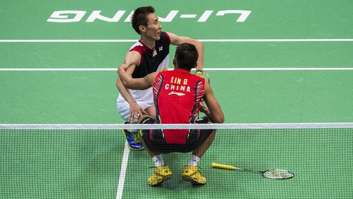 GUANGZHOU, CHINA - AUGUST 11: Injured Lee Chong Wei of Malaysia (L) is attended to by Lin Dan of China during the mens singles final match during the Badminton World Championships at the Tianhe Gymnasium on August 11, 2013 in Guangzhou, China.  (Photo by Victor Fraile/Getty Images)