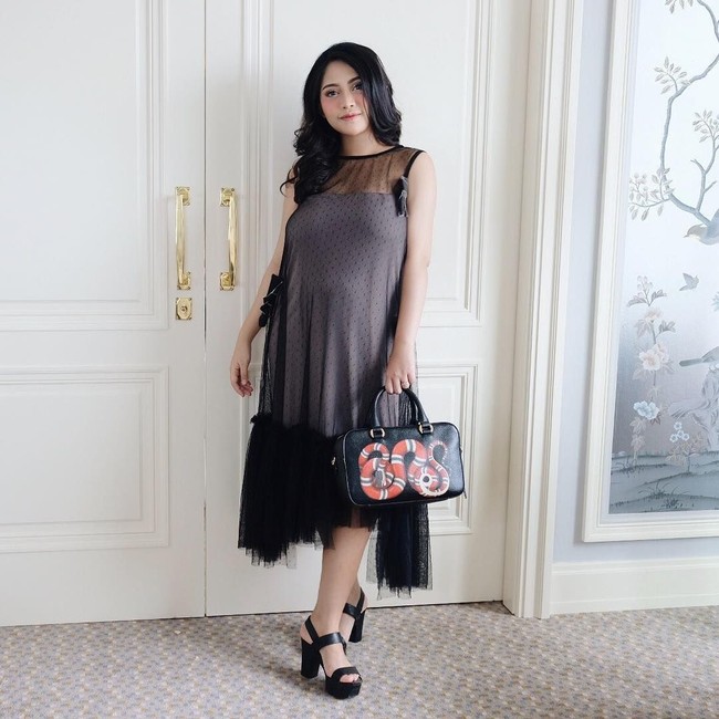 Bergaya ootd saat masih hamil putranya Xabiru, Rachel Vennya tampak memakai dress hitam dengan detail rok tutu. Penampilannya yang serba hitam dilengkapinya dengan tas Gucci seri Kingsnake Print Leather seharga AU$ 2.170 atau sekitar Rp 23 jutaan. Foto: Dok. Instagram Rachel Vennya