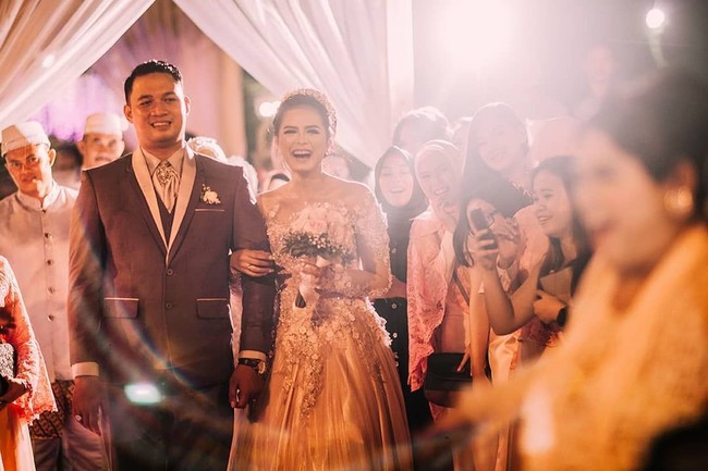 Kebahagiaan Bripda Ismi Aisyah dan sang suami, Joddy Adhi Nugraha, berlanjut di pesta resepsi mereka yang digelar di Pendopo Papuri (Saung Sunda), Bandung. Saat resepsi, Bripda Ismi mengenakan gaun dengan detail bordir bunga. Foto: Instagram/ismiaisyah20,epulpermadi