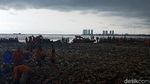 Awan Gelap Payungi Petugas Bersihkan Lautan Sampah di Teluk Jakarta