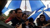 Sandiaga diwawancara wartawan di kawasan Ancol. Saat itu kondisi hujan. Sandiaga memegang payungnya sendiri.